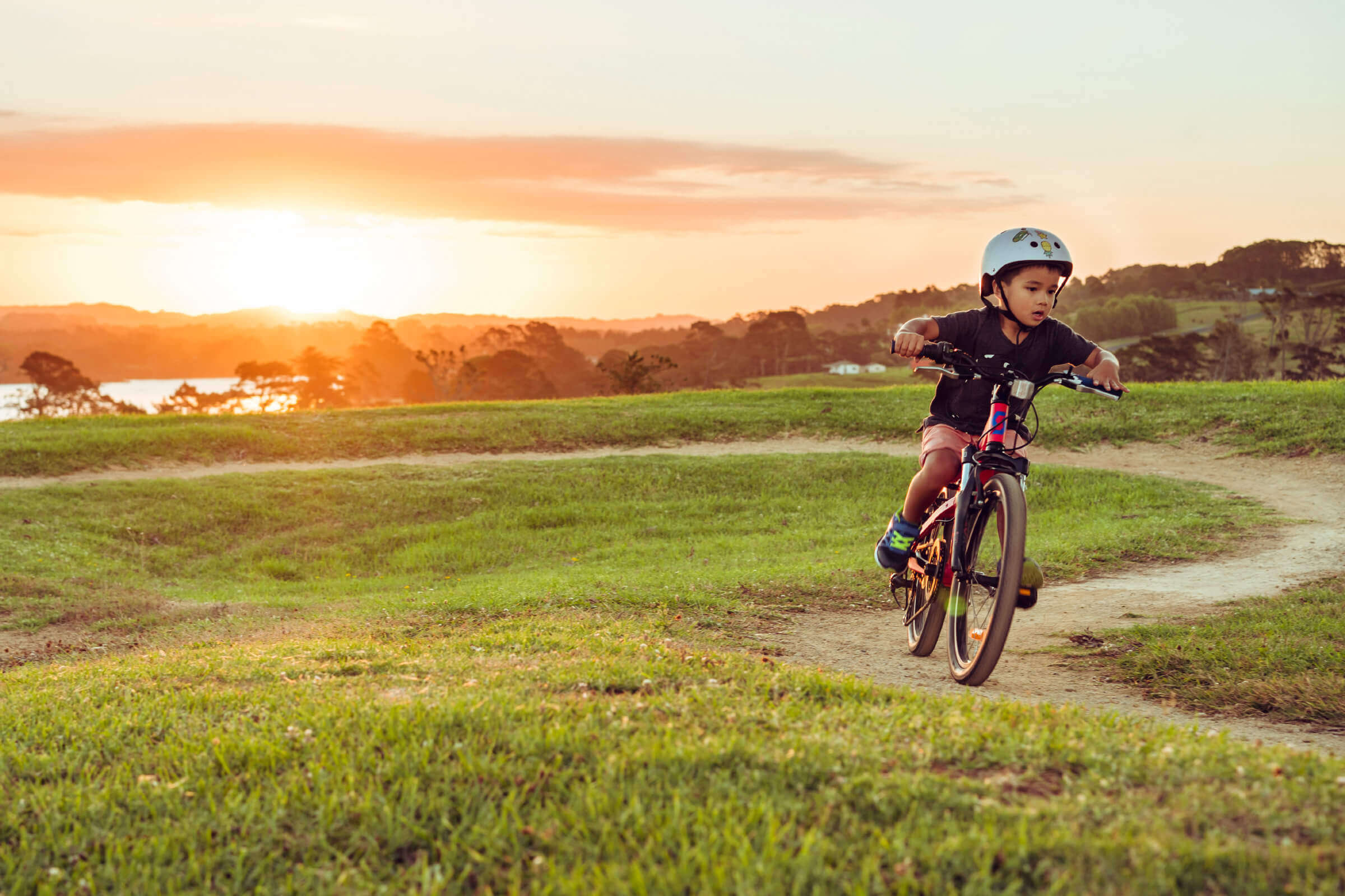 Child riding bike at sunset