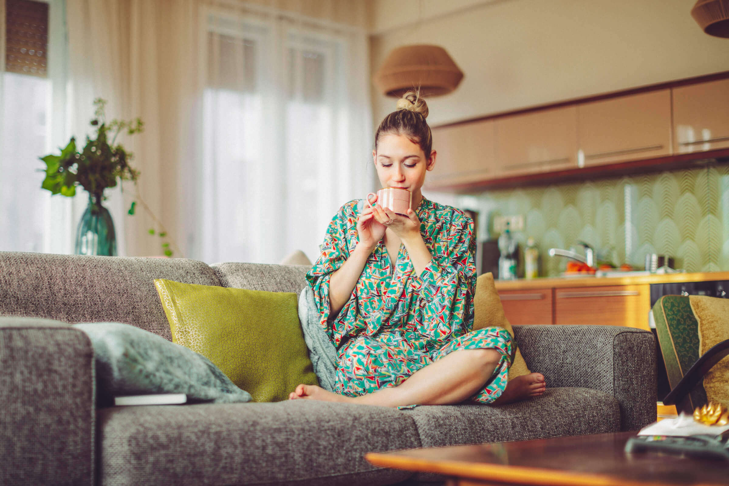 Women drinking tea on a sofa