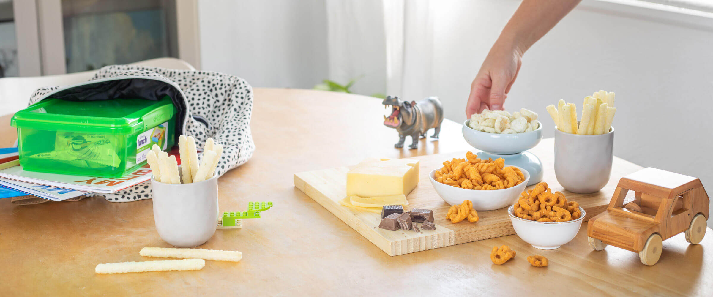 Table with kids lunchbox, toys and health snacks