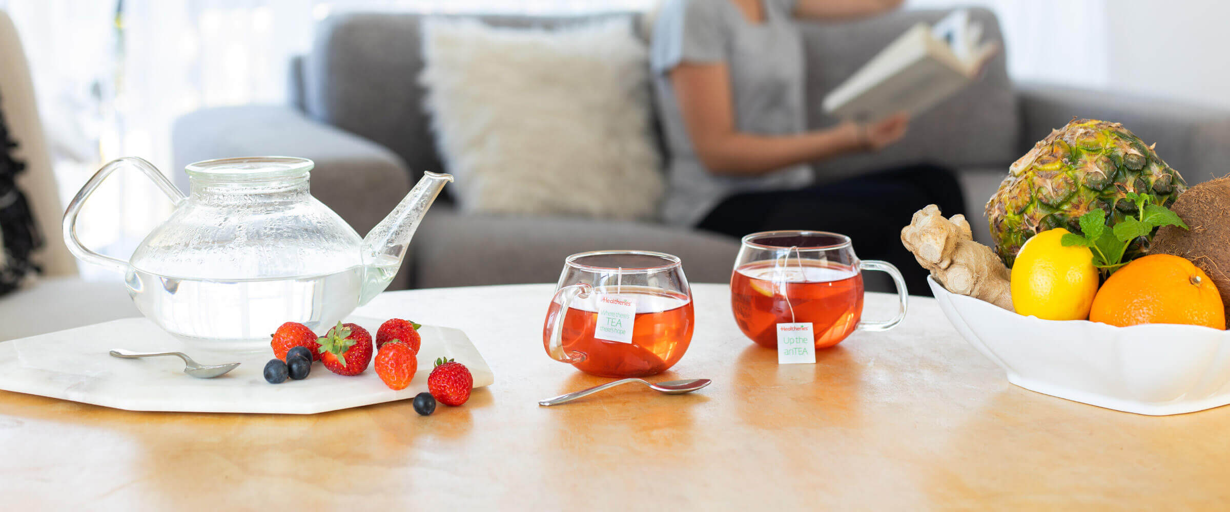 Women relaxing with 2 cups of berry tea on a coffee table